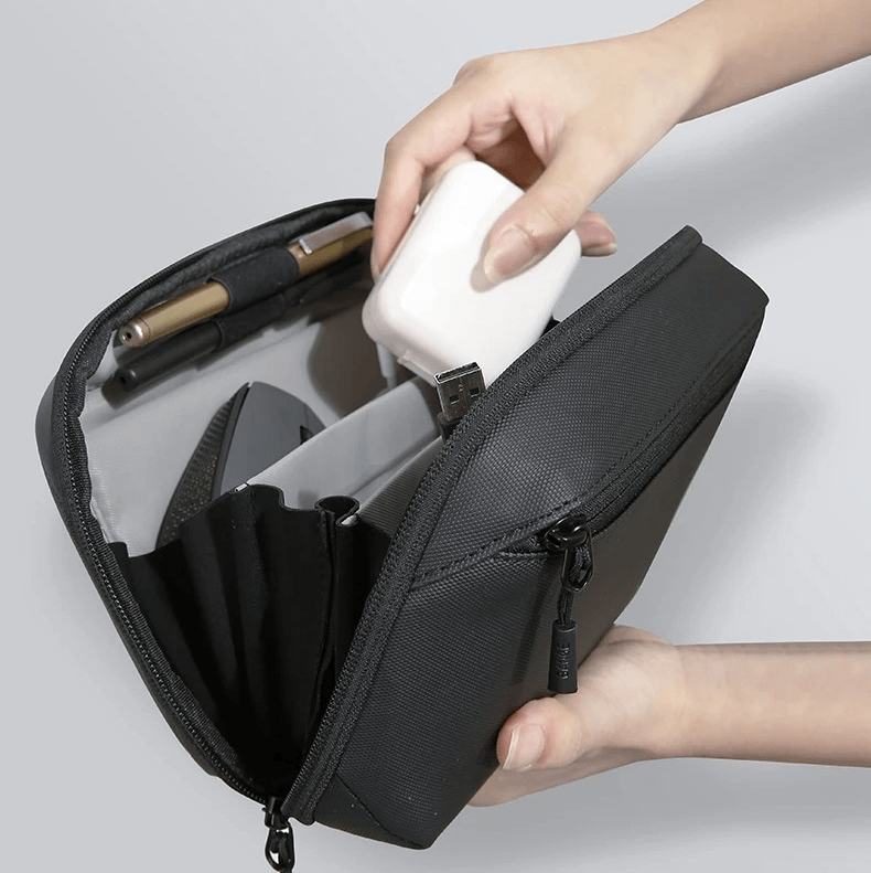 Black travel case with a 70-degree opening design, showing a hand placing a white item inside on a gray background.